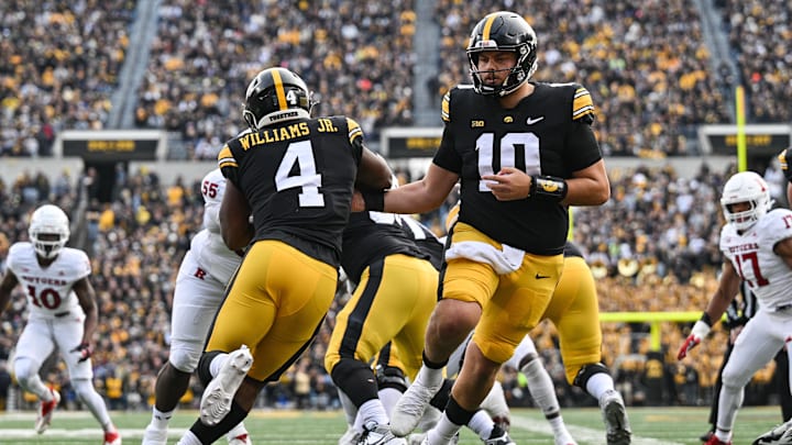 Nov 11, 2023; Iowa City, Iowa, USA; Iowa Hawkeyes quarterback Deacon Hill (10) hands the ball off to running back Leshon Williams (4) against the Rutgers Scarlet Knights during the first quarter at Kinnick Stadium. Mandatory Credit: Jeffrey Becker-USA TODAY Sports
