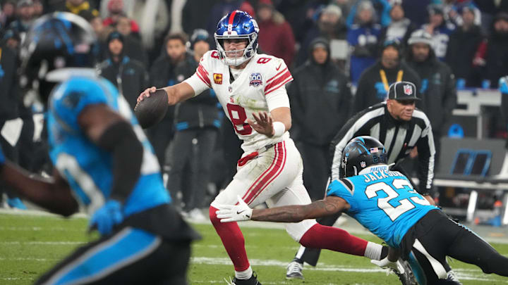 Nov 10, 2024; Munich, Germany; New York Giants quarterback Daniel Jones (8) is pressured by Carolina Panthers cornerback Dane Jackson (23) in the second half during the 2024 NFL Munich Game at Allianz Arena. Mandatory Credit: Kirby Lee-Imagn Images