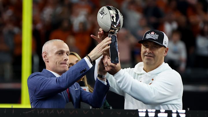 Dec 2, 2023; Arlington, TX, USA;  Big 12 commissioner Brett Yormark hands the Big 12 championship to Texas Longhorns head coach Steve Sarkisian after the win against the Oklahoma State Cowboys at AT&T Stadium. Mandatory Credit: Kevin Jairaj-Imagn Images