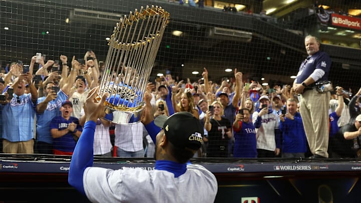 Nov 1, 2023; Phoenix, Arizona, USA;  Texas Rangers relief pitcher Aroldis Chapman (45) holds the trophy up for the fans after winning the 2023 World Series in five games against the Arizona Diamondbacks at Chase Field. Mandatory Credit: Mark J. Rebilas-Imagn Images