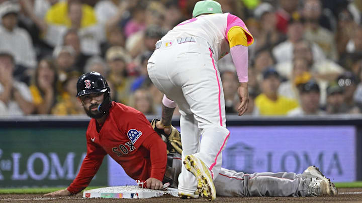 Aug 8, 2025; San Diego, California, USA; Boston Red Sox catcher Connor Wong (12) slides into third base ahead of the tag of San Diego Padres third baseman Manny Machado (13) during the fifth inning at Petco Park. Mandatory Credit: Denis Poroy-Imagn Images