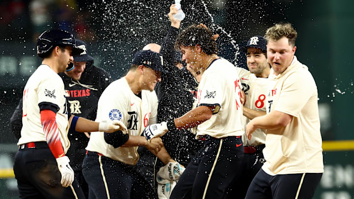 Texas Rangers right fielder Dustin Harris (38) celebrates with teammates after hitting the game-winning double against the Houston Astros during the twelfth inning  at Globe Life Field. 
