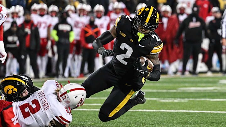 Nov 29, 2024; Iowa City, Iowa, USA; Iowa Hawkeyes running back Kaleb Johnson (2) runs the ball as Nebraska Cornhuskers defensive back Isaac Gifford (2) makes the tackle during the third quarter at Kinnick Stadium. Mandatory Credit: Jeffrey Becker-Imagn Images