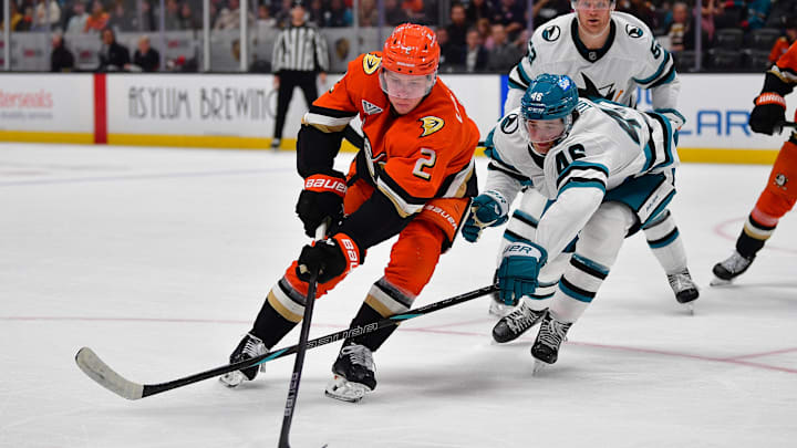 Apr 1, 2025; Anaheim, California, USA; Anaheim Ducks defenseman Jackson LaCombe (2) moves the puck against San Jose Sharks center Cam Lund (46) during the second period at Honda Center. Mandatory Credit: Gary A. Vasquez-Imagn Images