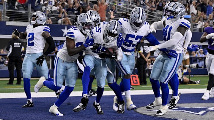 The Dallas Cowboys' defense celebrates a touchdown by cornerback Andrew Booth against the Baltimore Ravens.
