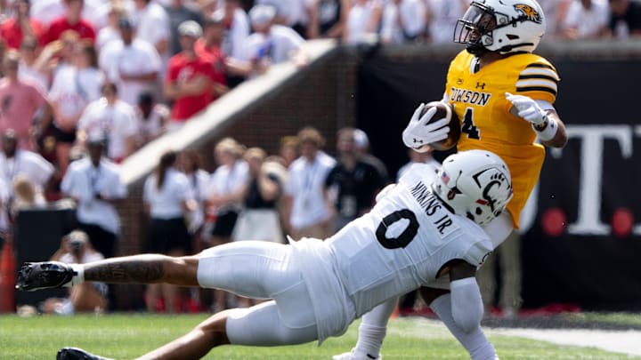 Cincinnati Bearcats defensive back Josh Minkins (0) tackles Towson Tigers wide receiver Lukkas Londono (14) in the first quarter of the College Football game at Nippert Stadium in Cincinnati on Saturday, Aug. 31, 2024.