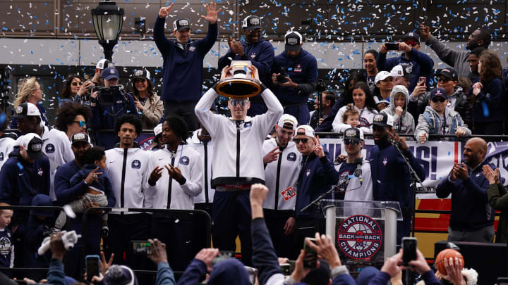 Apr 13, 2024; Hartford, CT, USA;  UConn Huskies center Donovan Clingan (32) holds up the championship trophy as the team celebrates in front of a large crowd of fans after the team's victory parade. Mandatory Credit: David Butler II-USA TODAY Sports
