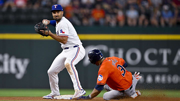 Aug 7, 2024; Arlington, Texas, USA; Texas Rangers second baseman Marcus Semien (2) puts out Houston Astros shortstop Jeremy Pena (3) as he turns a double play during the ninth inning at Globe Life Field. 