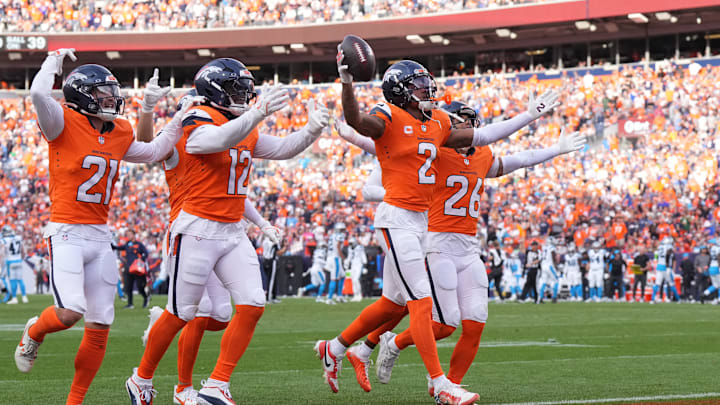 Oct 27, 2024; Denver, Colorado, USA; Denver Broncos cornerback Pat Surtain II (2) celebrates his interception with cornerback Riley Moss (21) and linebacker Kwon Alexander (12) and safety Devon Key (26) in the third quarter against the Carolina Panthers at Empower Field at Mile High. Mandatory Credit: Ron Chenoy-Imagn Images