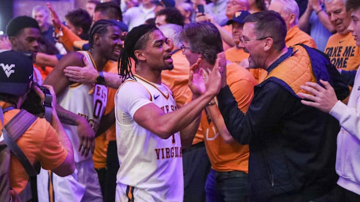 Feb 28, 2026; Morgantown, West Virginia, USA; West Virginia Mountaineers guard Jasper Floyd (1) celebrates with fans after defeating the BYU Cougars at Hope Coliseum. Mandatory Credit: Ben Queen-Imagn Images