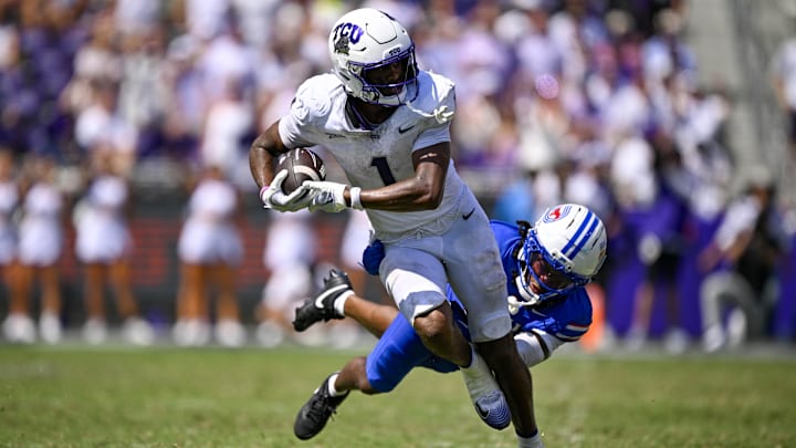 Sep 20, 2025; Fort Worth, Texas, USA; TCU Horned Frogs wide receiver Eric McAlister (1) breaks the tackle of SMU Mustangs cornerback Jaelyn Davis-Robinson (13) and scores a touchdown during the second half at Amon G. Carter Stadium. Mandatory Credit: Jerome Miron-Imagn Images