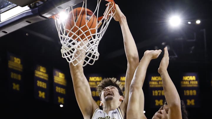 Feb 24, 2026; Ann Arbor, Michigan, USA;  Michigan Wolverines center Aday Mara (15) dunks against Minnesota Golden Gophers guard Isaac Asuma (1) in the first half at Crisler Center. Mandatory Credit: Rick Osentoski-Imagn Images