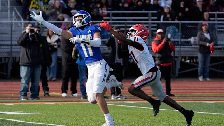 Novi Detroit Catholic Central (11) Gideon Gash stretches out on a ball thrown too high for him as East Kentwood (11) Stephan Jones defends during the first half of the MHSAA Division 1 football semifinals between Novi Detroit Catholic Central and East Kentwood at Jackson High School in Jackson on Saturday, Nov. 22, 2025.