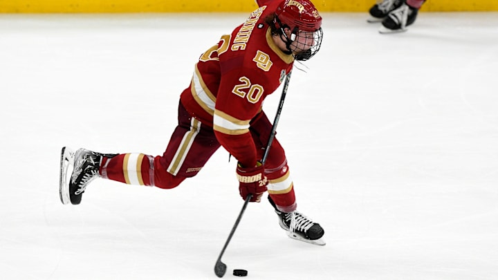 Apr 7, 2022; Boston, MA, USA; Denver Pioneers defenseman Mike Benning (20) shoots the puck on net during the second period of a game against the Michigan Wolverines in the 2022 Frozen Four college ice hockey national semifinals at the TD Garden. Mandatory Credit: Brian Fluharty-Imagn Images