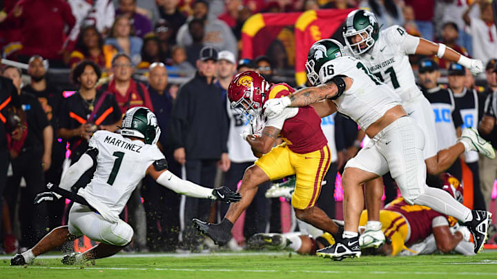 Sep 20, 2025; Los Angeles, California, USA; Michigan State Spartans wide receiver Omari Kelly (1) runs the ball against Michigan State Spartans edge David Santiago (41) defensive lineman Grady Kelly (16) and defensive back Nikai Martinez (1) during the first half at the Los Angeles Memorial Coliseum. Mandatory Credit: Gary A. Vasquez-Imagn Images Sep 20, 2025; Los Angeles, California, USA; Michigan State Spartans wide receiver Omari Kelly (1) runs the ball against Michigan State Spartans edge David Santiago (41) defensive lineman Grady Kelly (16) and defensive back Nikai Martinez (1) during the first half at the Los Angeles Memorial Coliseum. Mandatory Credit: Gary A. Vasquez-Imagn Images