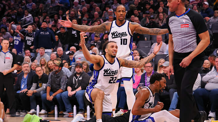 Mar 19, 2025; Sacramento, California, USA; Sacramento Kings players forward/guard DeMar DeRozan (10), guard Devin Carter (22) and guard Malik Monk (0) react as referee Nate Green (41) allows Cleveland Cavaliers forward/guard Isaac Okoro (35) to call a time out from the floor during the fourth quarter at Golden 1 Center. Mandatory Credit: Kelley L Cox-Imagn Images