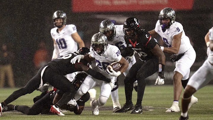 Nov 30, 2024; Cincinnati, Ohio, USA; TCU Horned Frogs running back Jeremy Payne (26) is tackled by Cincinnati Bearcats linebacker Jiquan Sanks (9) in the third quarter at Nippert Stadium. Mandatory Credit: Albert Cesare/USA TODAY Network via Imagn Images