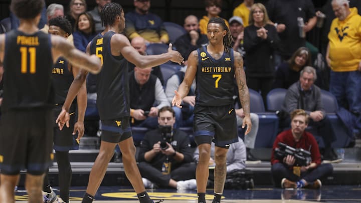 Feb 8, 2025; Morgantown, West Virginia, USA; West Virginia Mountaineers guard Javon Small (7) celebrates with West Virginia Mountaineers guard Toby Okani (5) following a score during the second half against the Utah Utes at WVU Coliseum. Mandatory Credit: Ben Queen-Imagn Images