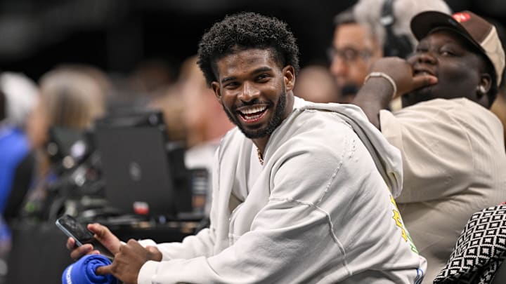 Colorado Buffaloes quarterback Shedeur Sanders laughs as he watches the game between the Dallas Mavericks and the Denver Nuggets during the second half at the American Airlines Center.