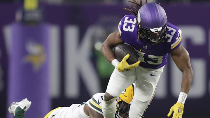 Dec 29, 2024; Minneapolis, Minnesota, USA; Green Bay Packers linebacker Edgerrin Cooper (56) tackles Minnesota Vikings running back Aaron Jones (33) in the second quarter at U.S. Bank Stadium. Mandatory Credit: Dan Powers/USA TODAY NETWORK-Wisconsin via Imagn Images