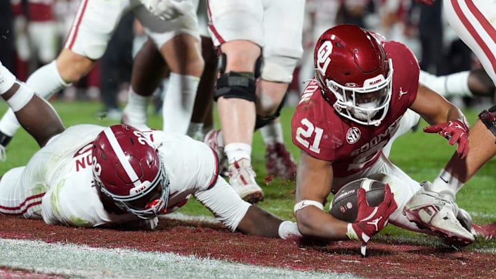 Oklahoma Sooners running back Xavier Robinson (21) scores a touchdown beside Alabama Crimson Tide defensive lineman LT Overton (22) during a college football game between the University of Oklahoma Sooners (OU) and the Alabama Crimson Tide at Gaylord Family - Oklahoma Memorial Stadium in Norman, Okla., Saturday, Nov. 23, 2024. Oklahoma won 24-3.