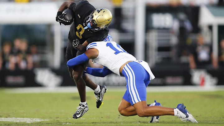 Oct 26, 2024; Orlando, Florida, USA;  Central Brigham Young Cougars saftey Faletau Satuala (10) tackles Florida Knights wide receiver Ja'Varrius Johnson (9) during the second half at FBC Mortgage Stadium. Mandatory Credit: Russell Lansford-Imagn Images