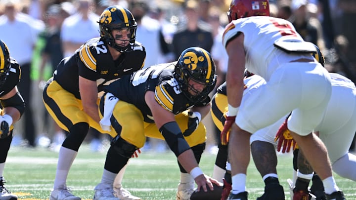 Sep 7, 2024; Iowa City, Iowa, USA; Iowa Hawkeyes quarterback Cade McNamara (12) prepares to take the snap from offensive lineman Logan Jones (65) against the Iowa State Cyclones during the first quarter at Kinnick Stadium. Mandatory Credit: Jeffrey Becker-Imagn Images Sep 7, 2024; Iowa City, Iowa, USA; Iowa Hawkeyes quarterback Cade McNamara (12) prepares to take the snap from offensive lineman Logan Jones (65) against the Iowa State Cyclones during the first quarter at Kinnick Stadium. Mandatory Credit: Jeffrey Becker-Imagn Images