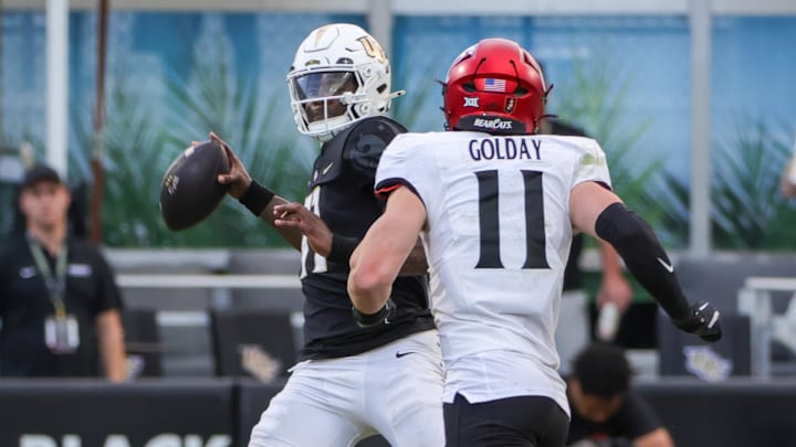 Oct 12, 2024; Orlando, Florida, USA; UCF Knights quarterback Jacurri Brown (11) looks to pass in front of Cincinnati Bearcats linebacker Jake Golday (11) during the second half at FBC Mortgage Stadium. Mandatory Credit: Mike Watters-Imagn Images