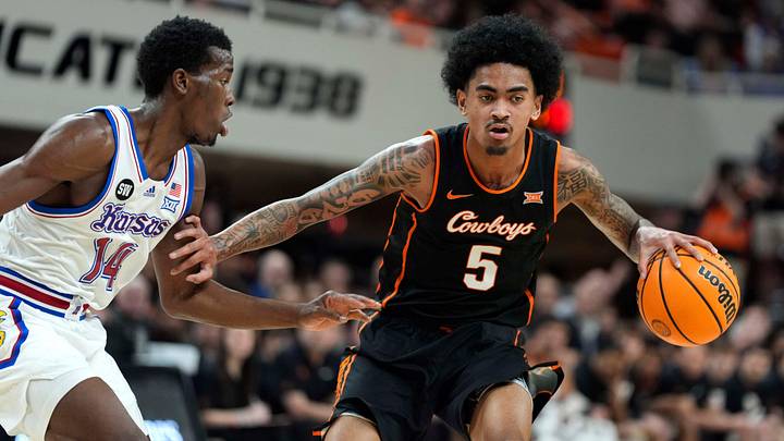 Oklahoma State Cowboys guard Vyctorius Miller (5) dribbles beside Kansas Jayhawks guard Melvin Council Jr. (14) during a men's college basketball game between the Oklahoma State Cowboys and the Kansas Jayhawks at Gallagher-Iba Arena in Stillwater, Okla., Wednesday, Feb. 18, 2026. Oklahoma State Cowboys guard Vyctorius Miller (5) dribbles beside Kansas Jayhawks guard Melvin Council Jr. (14) during a men's college basketball game between the Oklahoma State Cowboys and the Kansas Jayhawks at Gallagher-Iba Arena in Stillwater, Okla., Wednesday, Feb. 18, 2026.
