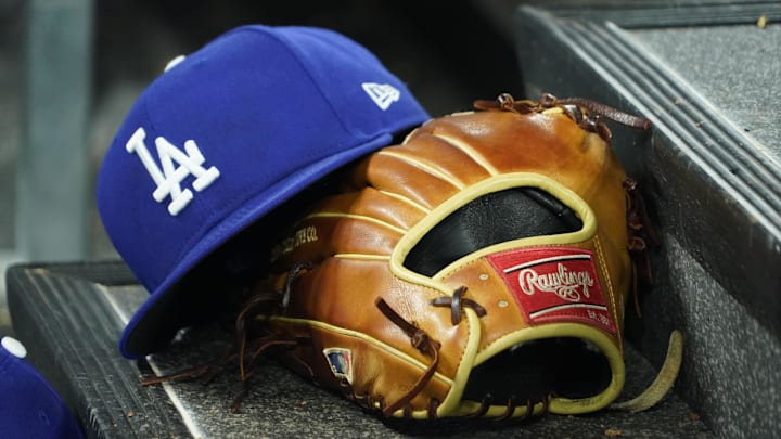 Apr 28, 2024; Toronto, Ontario, CAN; A hat and glove of an Los Angeles Dodgers player durng a game against the Toronto Blue Jays at Rogers Centre. Mandatory Credit: John E. Sokolowski-Imagn Images