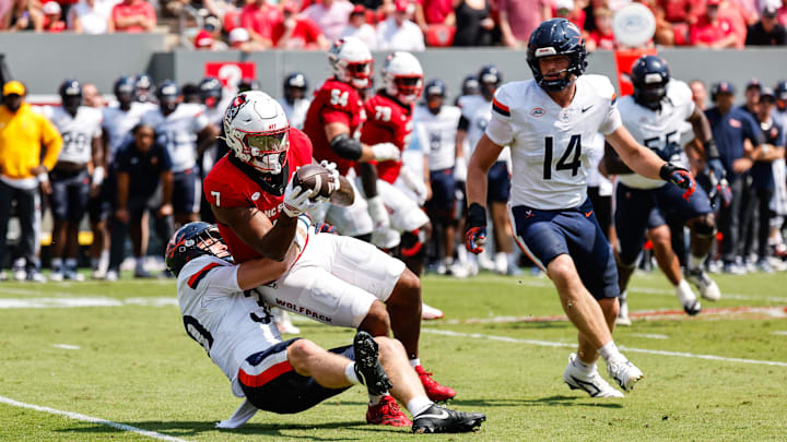 Sep 6, 2025; Raleigh, North Carolina, USA; Virginia Cavaliers safety Ethan Minter (30) tackles North Carolina State Wolfpack tight end Justin Joly (7) during the first half of the game at Carter-Finley Stadium. Mandatory Credit: Jaylynn Nash-Imagn Images