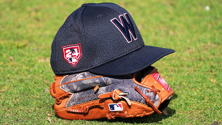 Feb 16, 2024; West Palm Beach, FL, USA; A Washington Nationals cap and glove rests in the outfield during workouts at spring training. 