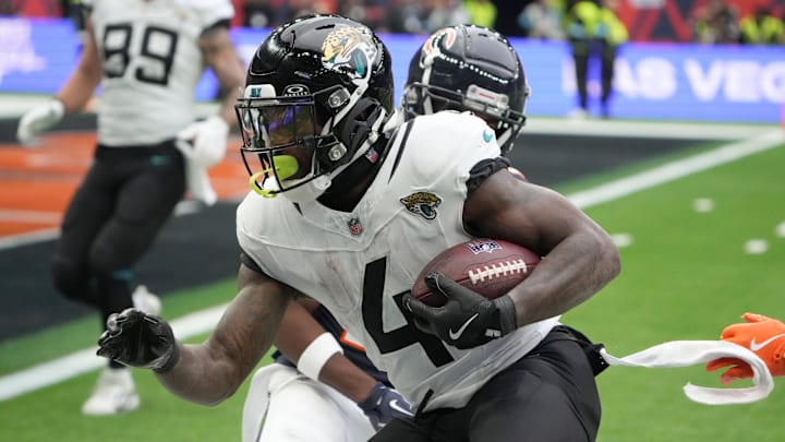 Oct 13, 2024; London, United Kingdom; Jacksonville Jaguars running back Tank Bigsby (4) carries the ball against Chicago Bears safety Elijah Hicks (22) in the second half during an NFL International Series game at Tottenham Hotspur Stadium. 