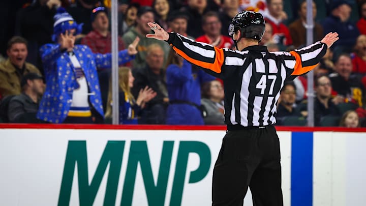 Mar 18, 2026; Calgary, Alberta, CAN; referee Mike Sullivan (47) calls no goal against the Calgary Flames during the second period against the St. Louis Blues at Scotiabank Saddledome. Mandatory Credit: Sergei Belski-Imagn Images