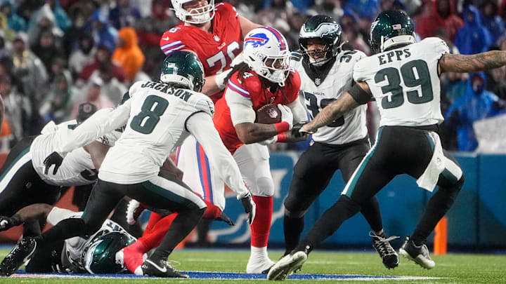Dec 28, 2025; Orchard Park, New York, USA; Buffalo Bills running back James Cook III (4) runs the ball against Philadelphia Eagles cornerback Adoree' Jackson (8), linebacker Jihaad Campbell (30) and safety Marcus Epps (39) during the second quarter at Highmark Stadium. Mandatory Credit: Gregory Fisher-Imagn Images