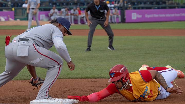 Blue Claws Eduardo Tait dives back to first as the Blue Rocks’ Roismar Quintana is late with the tag. 