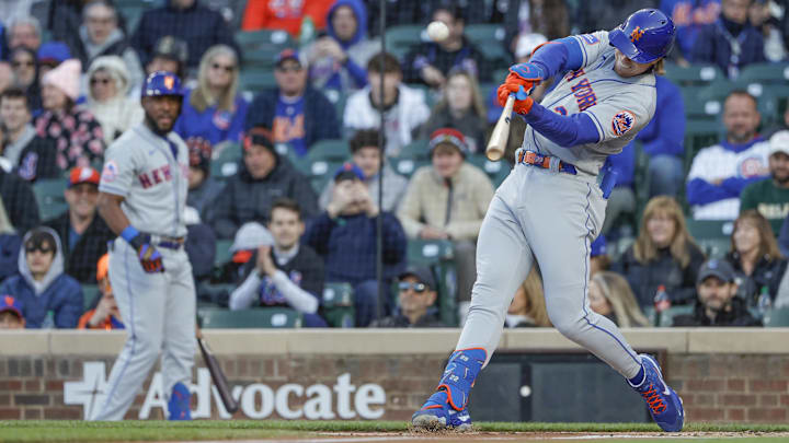 May 25, 2023; Chicago, Illinois, USA; New York Mets third baseman Brett Baty (22) hits a sacrifice RBI against the Chicago Cubs during the first inning at Wrigley Field. Mandatory Credit: Kamil Krzaczynski-Imagn Images