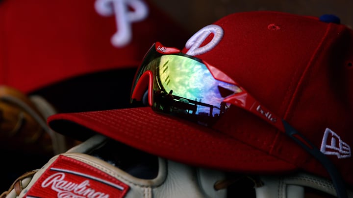 A view of the sky and ballpark in the reflection of a pair of sunglasses in the dugout on an official Phillies New Era cap in the game of the Philadelphia Phillies against the Cincinnati Reds at Great American Ball Park.