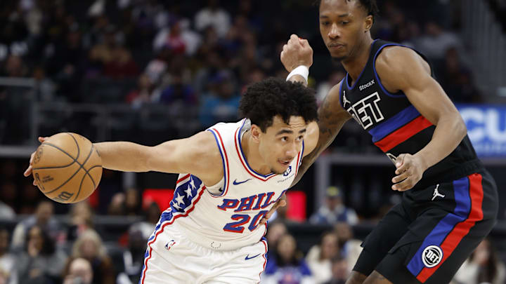 Nov 30, 2024; Detroit, Michigan, USA;  Philadelphia 76ers guard Jared McCain (20) dribbles on Detroit Pistons forward Ronald Holland II (00) in the first half at Little Caesars Arena. Mandatory Credit: Rick Osentoski-Imagn Images
