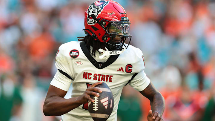Nov 15, 2025; Miami Gardens, Florida, USA; NC State Wolfpack quarterback CJ Bailey (11) looks for a passing option against the Miami Hurricanes during the second quarter at Hard Rock Stadium. Mandatory Credit: Sam Navarro-Imagn Images