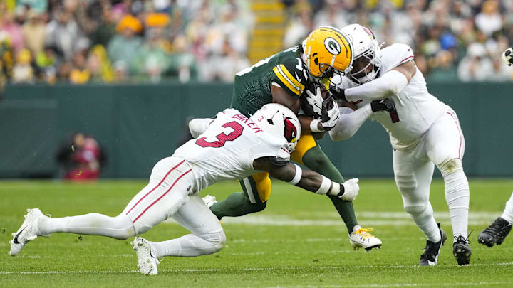 Green Bay Packers wide receiver Dontayvion Wicks (13) is tackled by Arizona Cardinals safety Budda Baker (3) and inside linebacker Kyzir White. Green Bay Packers wide receiver Dontayvion Wicks (13) is tackled by Arizona Cardinals safety Budda Baker (3) and inside linebacker Kyzir White.