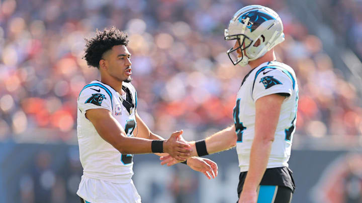 CHICAGO, ILLINOIS - OCTOBER 06: Bryce Young #9 shakes hands with Andy Dalton #14 of the Carolina Panthers against the Chicago Bears during the fourth quarter at Soldier Field on October 06, 2024 in Chicago, Illinois. 