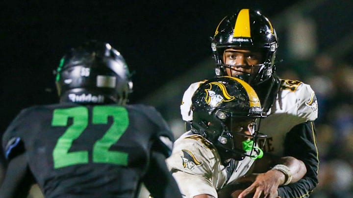 American Heritage QB Leon Strawder hands the ball off during the Patriots' Class 4A state semifinal football game at Choctawhatchee. AHP won 31-14 and advanced to the state championship game against Orlando Jones on Saturday, Dec. 13, at FIU in Miami.