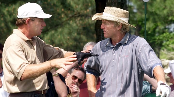 Nick Price (L) of Zimbabwe talks to Greg Norman (R)