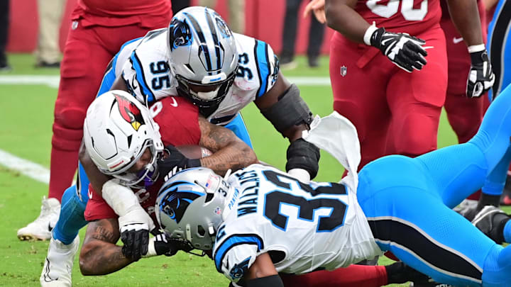 Sep 14, 2025; Glendale, Arizona, USA;   Carolina Panthers linebacker Trevin Wallace (32) and defensive end Derrick Brown (95) tackle Arizona Cardinals running back James Conner (6) during the third quarter at State Farm Stadium. Mandatory Credit: Matt Kartozian-Imagn Images