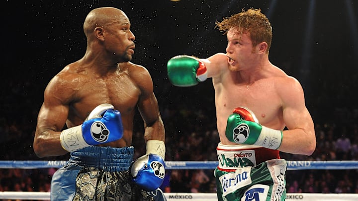 Sep 14, 2013; Las Vegas, NV, USA; Floyd Mayweather Jr. (blue gloves) and Canelo Alvarez (green gloves) battle at their WBC and WBA super welterweight titles fight at MGM Grand Garden Arena. Mayweather won by a majority decision. Mandatory Credit: Jayne Kamin-Oncea-Imagn Images