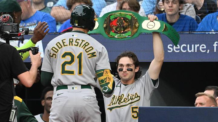 May 30, 2025; Toronto, Ontario, CAN;  Athletics first baseman Tyler Soderstrom (21) receives the team home run belt from shortstop Jacob Wilson (5) after hitting a solo home run against the Toronto Blue Jays in the second inning at Rogers Centre. Mandatory Credit: Dan Hamilton-Imagn Images