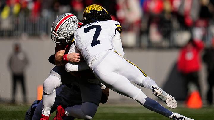 Ohio State Buckeyes quarterback Will Howard (18) is hit by Michigan Wolverines defensive back Makari Paige (7) during the first half of the NCAA football game at Ohio Stadium in Columbus on Saturday, Nov. 30, 2024. Howard left the game briefly after the play.
