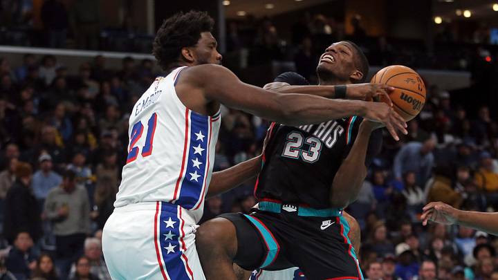 Dec 30, 2025; Memphis, Tennessee, USA; Philadelphia 76ers center Joel Embiid (21) knocks the ball loose from Memphis Grizzlies forward Cedric Coward (23) during the third quarter at FedExForum. Mandatory Credit: Petre Thomas-Imagn Images