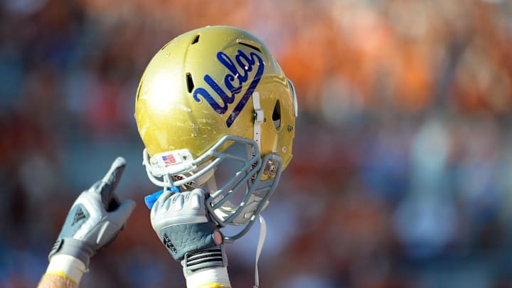 Sept 25, 2010; Austin, TX, USA; A member of the UCLA Bruins holds up his helmet to acknowledge their fans against the Texas Longhorns during the fourth quarter at Texas Memorial Stadium. UCLA beat Texas 34-12. Mandatory Credit: Brendan Maloney-Imagn Images Sept 25, 2010; Austin, TX, USA; A member of the UCLA Bruins holds up his helmet to acknowledge their fans against the Texas Longhorns during the fourth quarter at Texas Memorial Stadium. UCLA beat Texas 34-12. Mandatory Credit: Brendan Maloney-Imagn Images